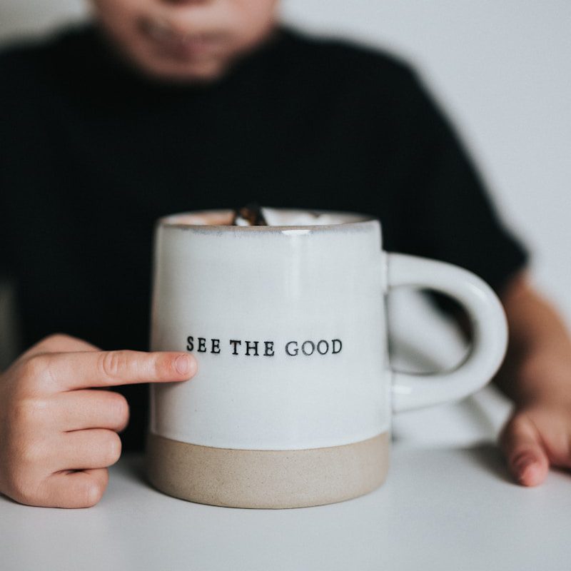 man in black long sleeve shirt holding white ceramic mug
